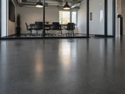 Dark grey epoxy floor in a glass walled meeting room